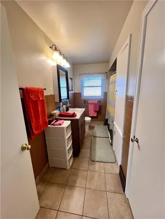 a bedroom with a bed table chair and a window