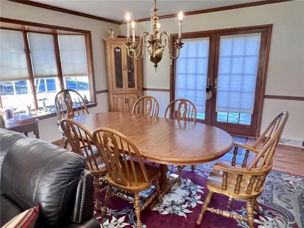 a dining room with furniture a chandelier and wooden floor