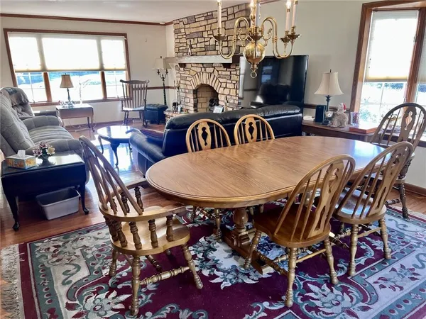a view of a dining room with furniture a fireplace and large windows