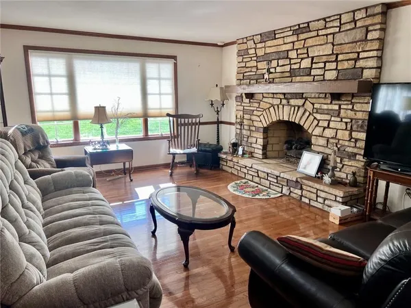a living room with furniture a large window and a fireplace