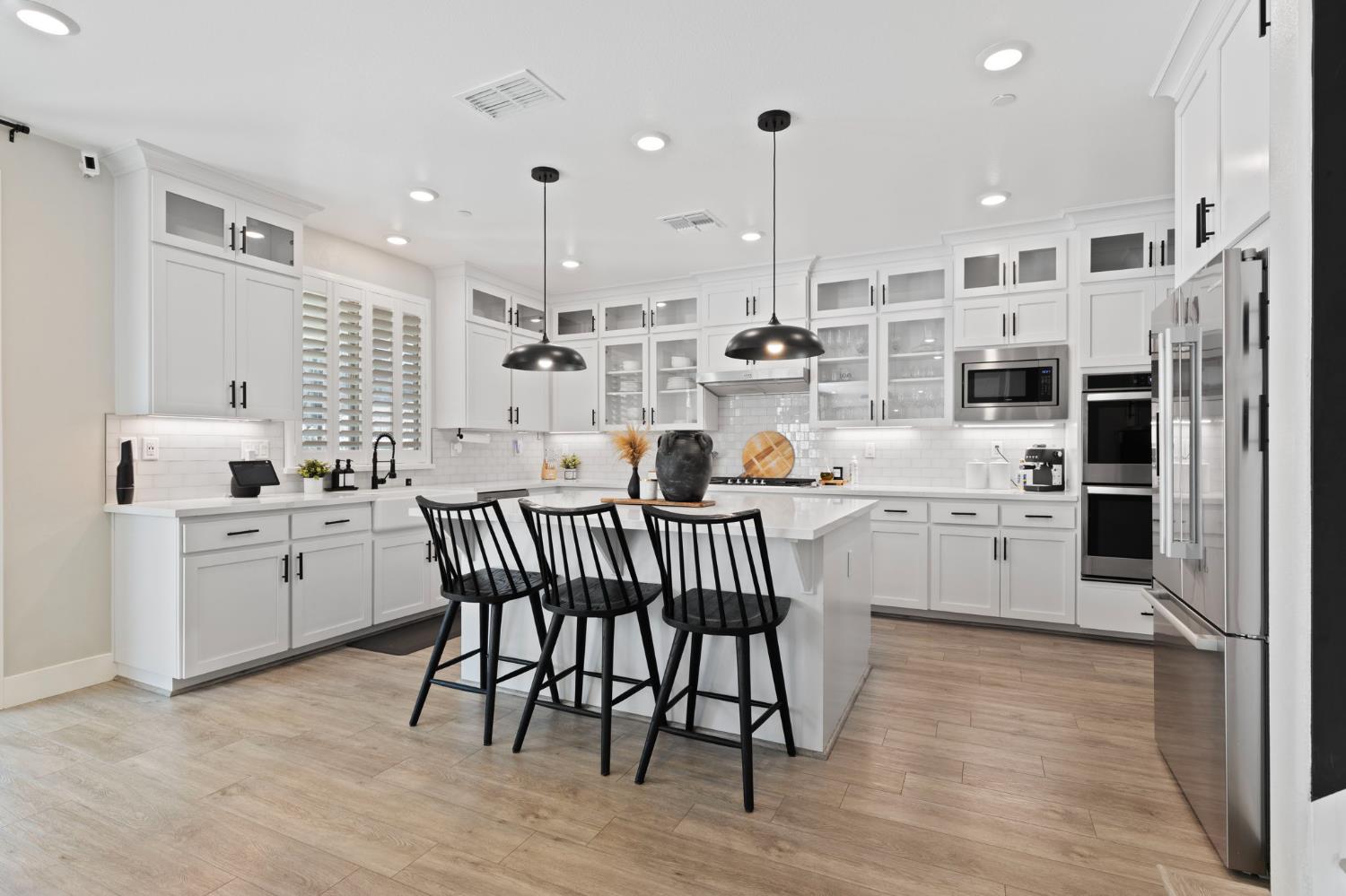 2948 Laredo Drive Rocklin, CA 95765 - Photo 18 of 54 a kitchen with white cabinets stainless steel appliances and kitchen island