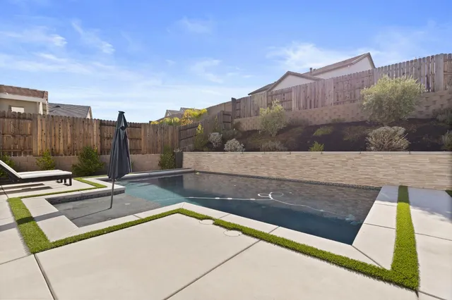 a view of a patio with couches table and chairs under an umbrella