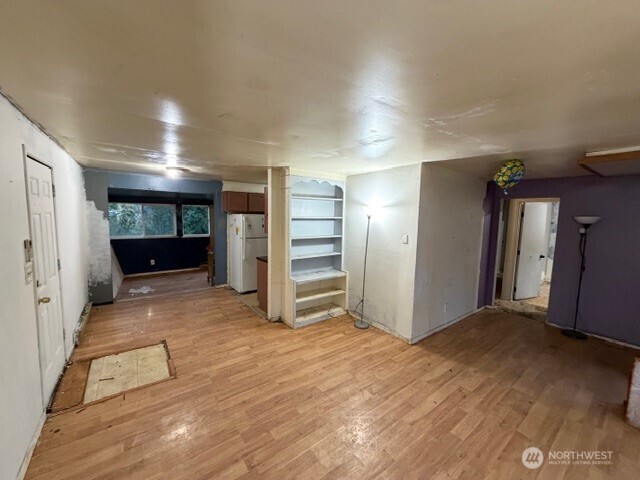 8915 10th Avenue South Seattle, WA 98108 - Photo 7 of 23 a view of empty room with wooden floor and kitchen
