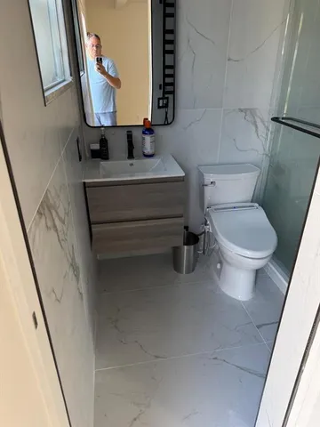 a bathroom with a toilet sink and mirror