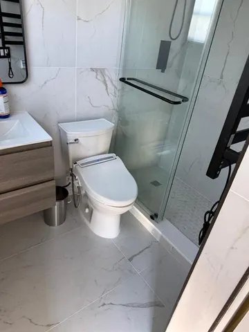 a white toilet sitting next to a bathroom sink