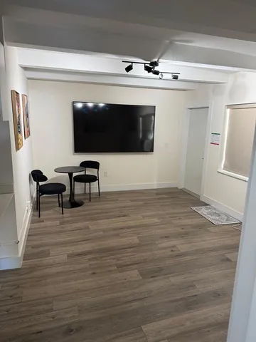 a view of a livingroom with wooden floor and white walls