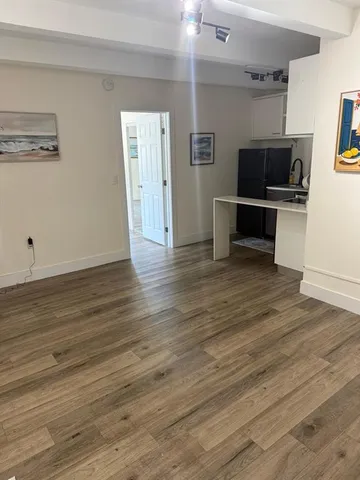a view of a kitchen with wooden floor and electronic appliances