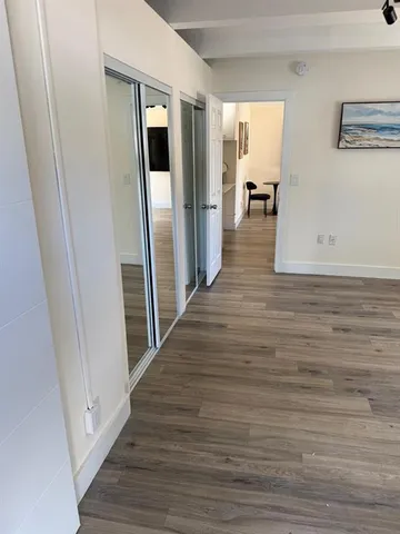 a view of a hallway with wooden floor and staircase