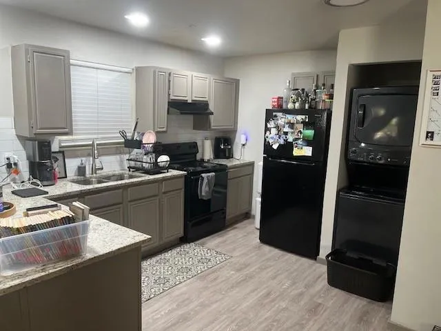 a kitchen with stainless steel appliances kitchen island granite countertop a refrigerator stove and sink