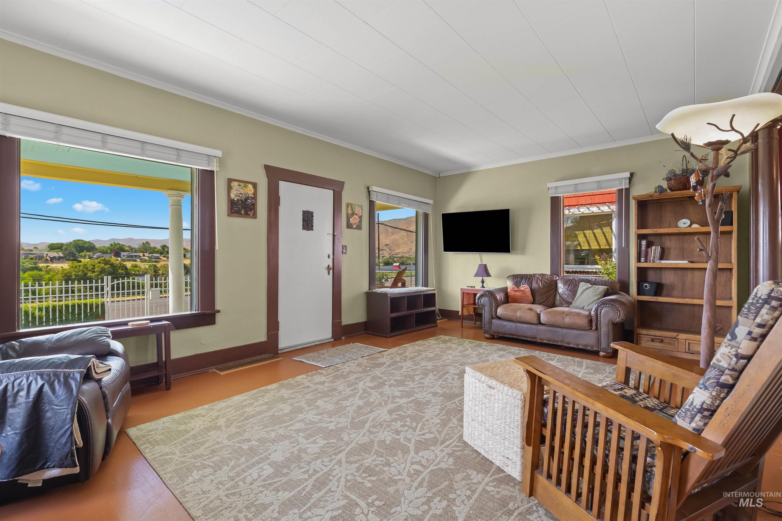 619 Prospect Avenue Lewiston, ID 83501 - Photo 8 of 37 Bright living area featuring wood-finish flooring, a white paneled ceiling, and multiple windows with white trim