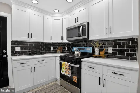 a kitchen with white cabinets and white appliances