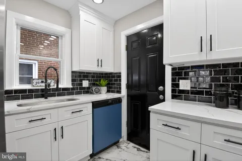 a kitchen with granite countertop a sink stainless steel appliances and cabinets