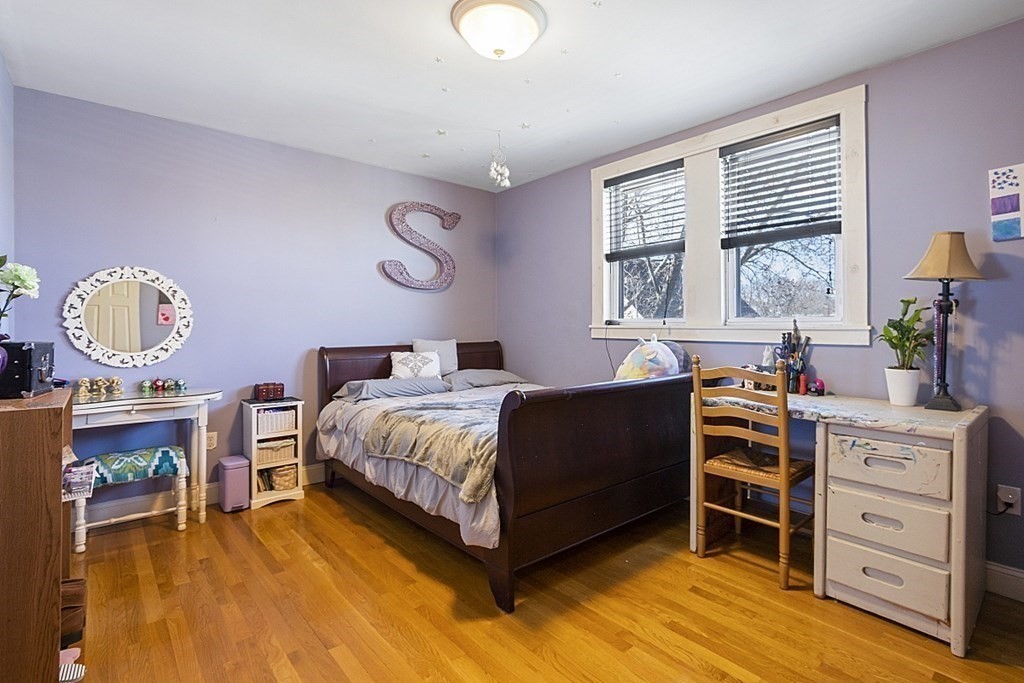 29 Ocean Avenue, Unit 4 Salem, MA 01970 - Photo 13 of 32 a bedroom with a bed and a chandelier