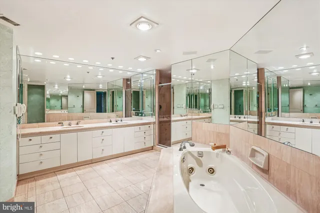 a large white bathroom with a large tub sink vanity and granite