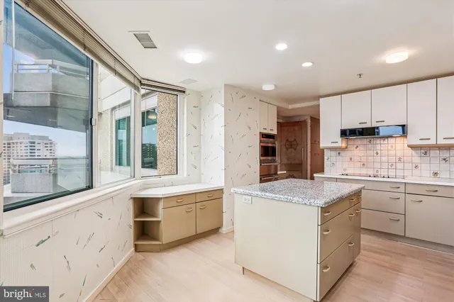 a kitchen with granite countertop white cabinets and white appliances