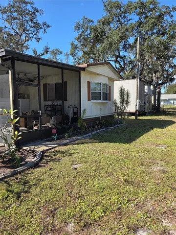 a backyard of a house with yard table and chairs