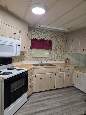 a kitchen with granite countertop a sink stainless steel appliances and cabinets