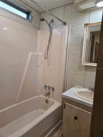 a bathroom with a sink a mirror and a bathtub