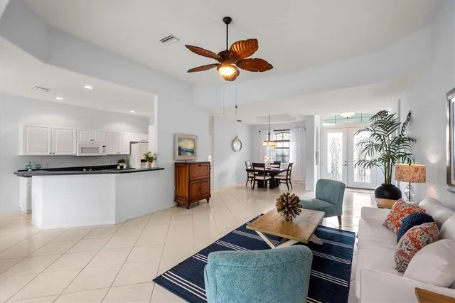 a living room with furniture kitchen view and a chandelier