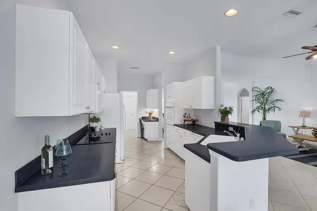 a kitchen with granite countertop a sink a stove and cabinets