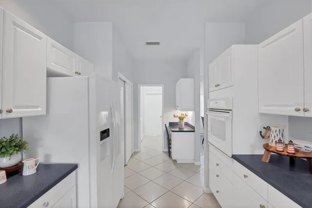 a kitchen with white cabinets and white appliances
