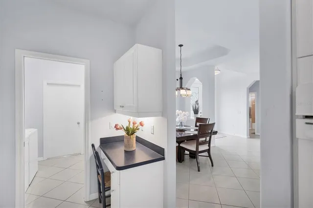a room with a table chairs and a refrigerator