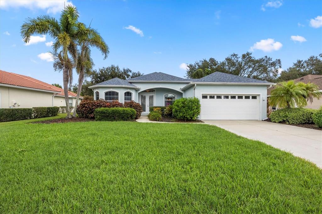 160 Wading Bird Drive Venice, FL 34292 - Photo 5 of 47 a front view of a house with a garden and trees