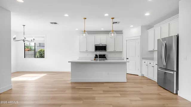 a view of kitchen with stainless steel appliances granite countertop a refrigerator a sink dishwasher a stove and a refrigerator