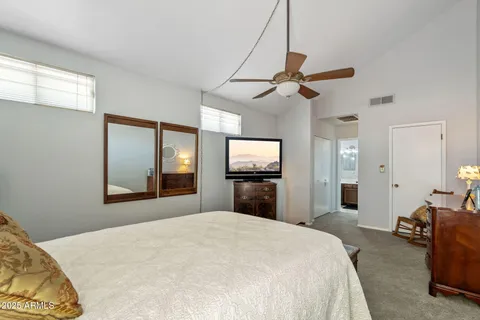 a bedroom with a bed and a flat tv screen on dresser