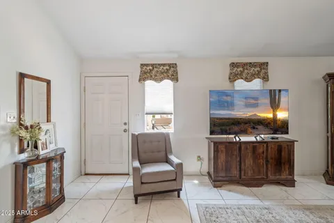 a living room with furniture a flat screen tv and kitchen view