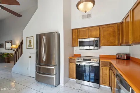 a kitchen with stainless steel appliances granite countertop a refrigerator sink and stove