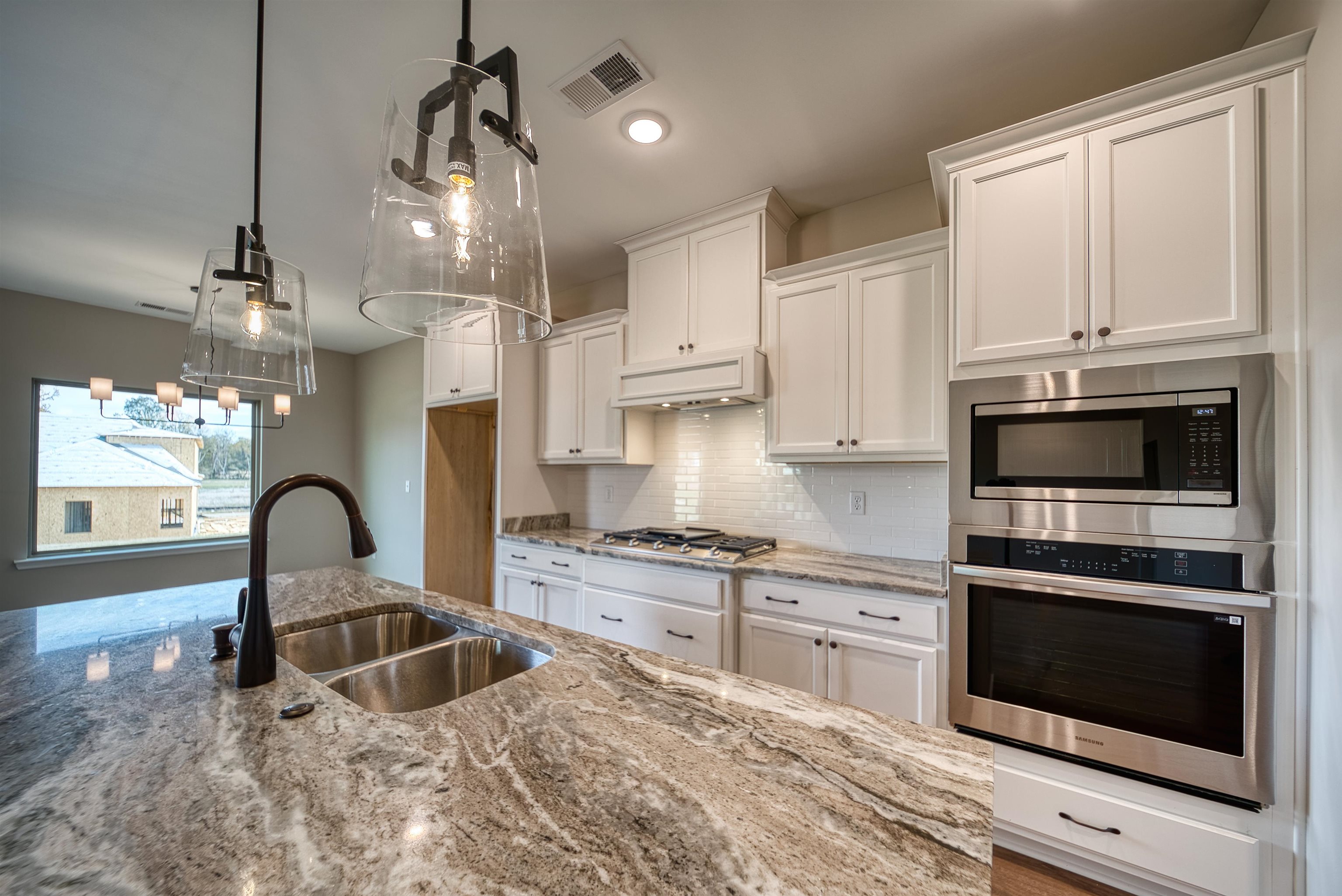 515 Garland Drive Covington, TN 38019 - Photo 17 of 38 a kitchen with granite countertop a stove a sink and a microwave