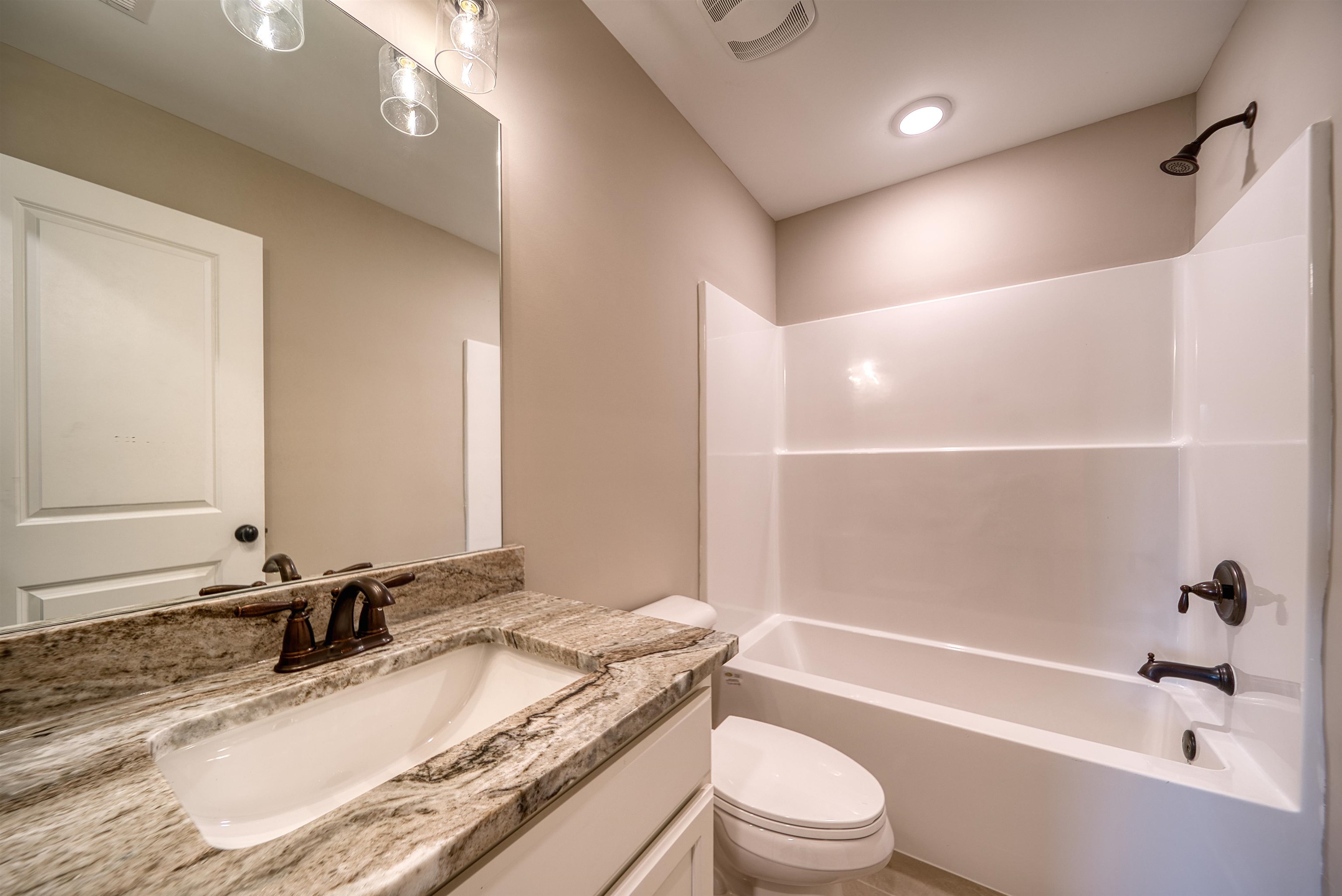 515 Garland Drive Covington, TN 38019 - Photo 38 of 38 a bathroom with a granite countertop bathtub shower sink vanity mirror and toilet