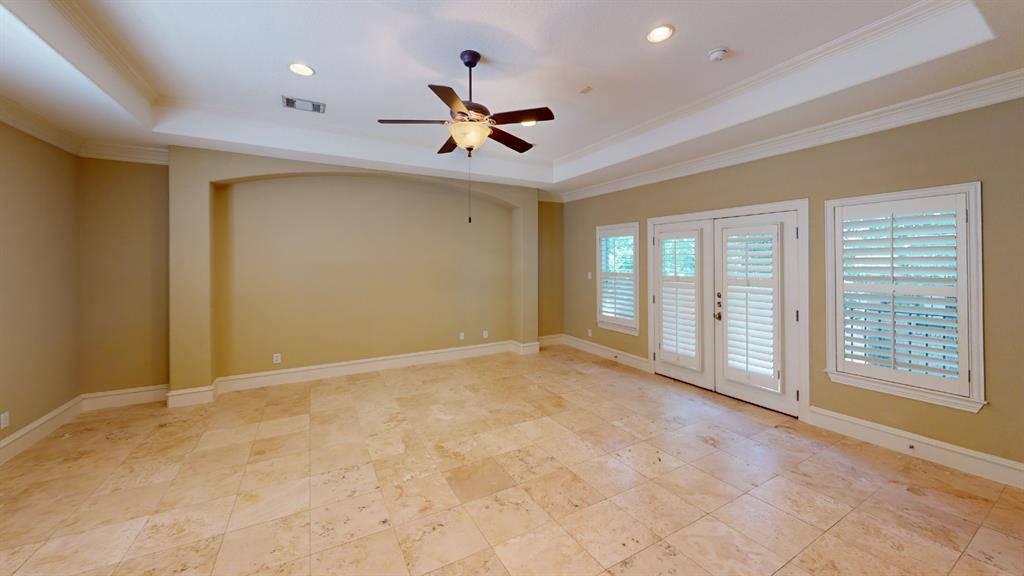 4516 Gilbert Avenue Dallas, TX 75219 - Photo 9 of 28 Spacious room featuring tile flooring, a tray ceiling with recessed lighting, and a ceiling fan