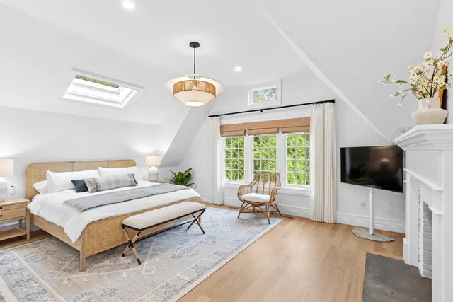 a spacious bedroom with a bed and a flat screen tv