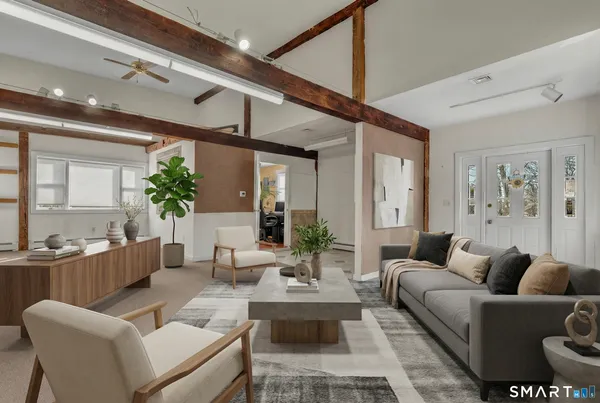 a living room with furniture kitchen view and a chandelier