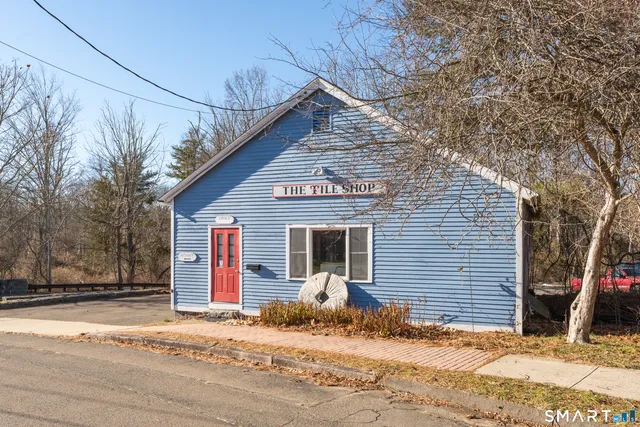 a front view of a house with a tree
