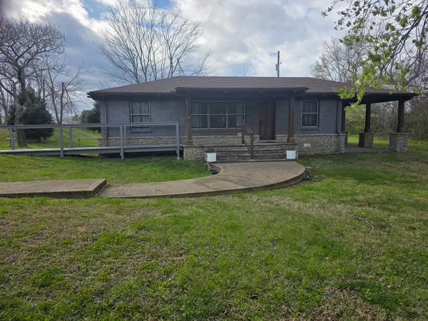 a front view of a house with a yard and trees