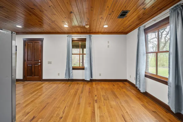 a view of empty room with wooden floor