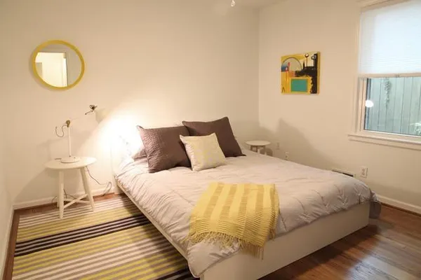 a bedroom with a bed and a painting on the wall