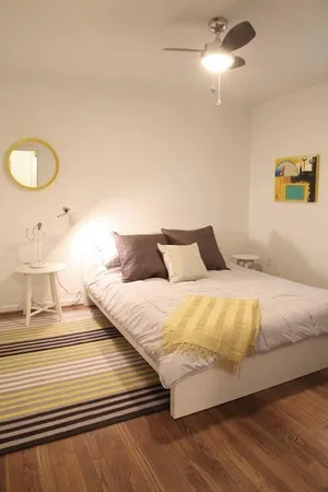 a bedroom with a bed and painting on the wall