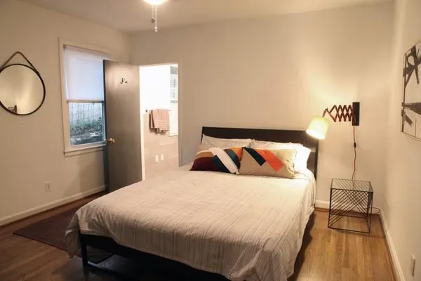 a bedroom with a bed and wooden floor