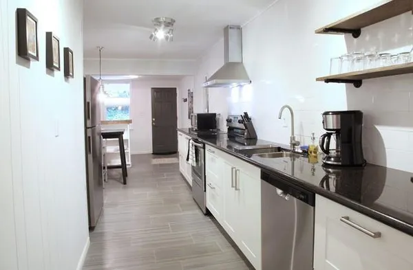 a kitchen with stainless steel appliances a sink stove and cabinets