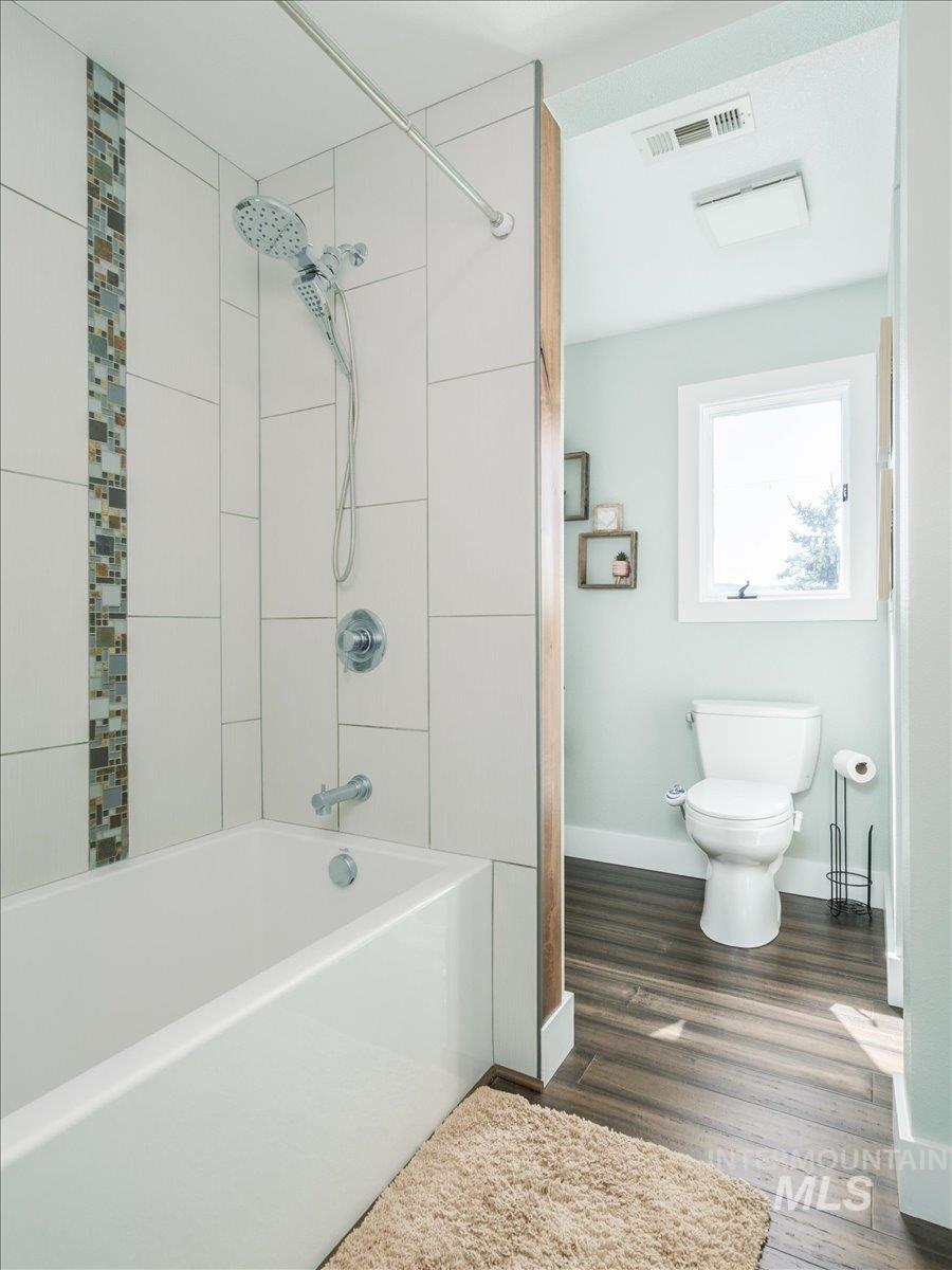 1401 Chokecherry Drive Pocatello, ID 83204 - Photo 29 of 46 Bathroom featuring a white tub, chrome fixtures, and white subway tile with a decorative mosaic accent