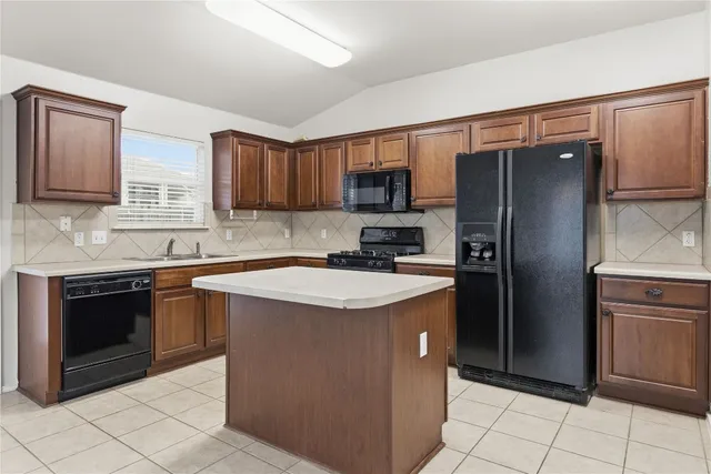 a kitchen with stainless steel appliances granite countertop a refrigerator stove a sink and a microwave