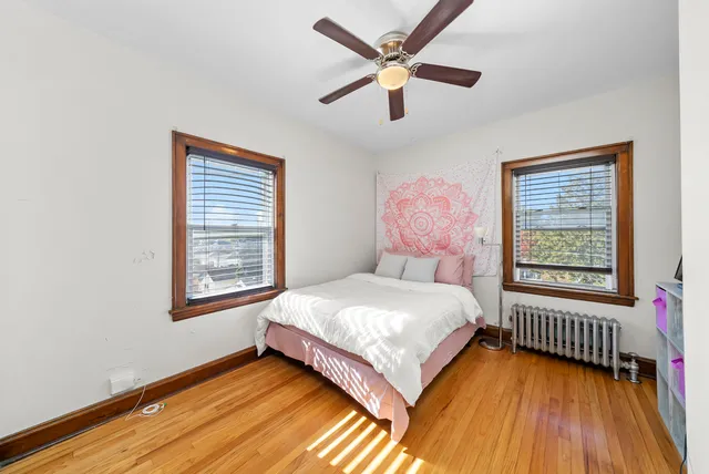 a bedroom with a bed next to a window and a chandelier