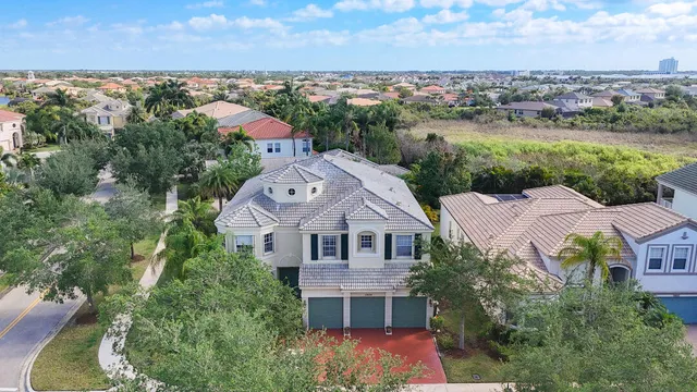 a view of a white house with large windows and a tree