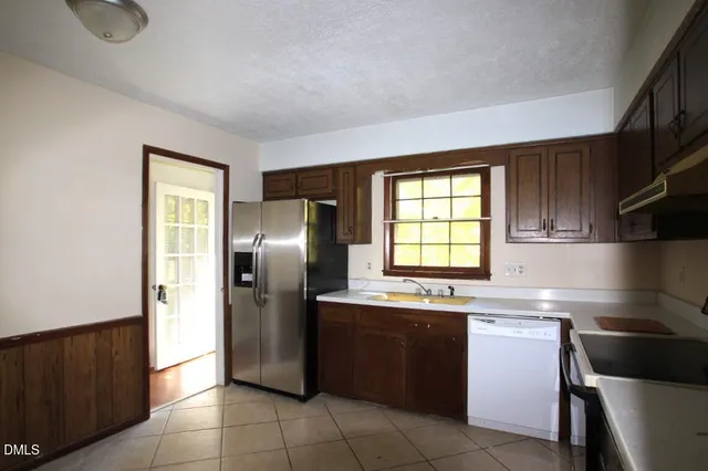 a kitchen with a sink window and refrigerator