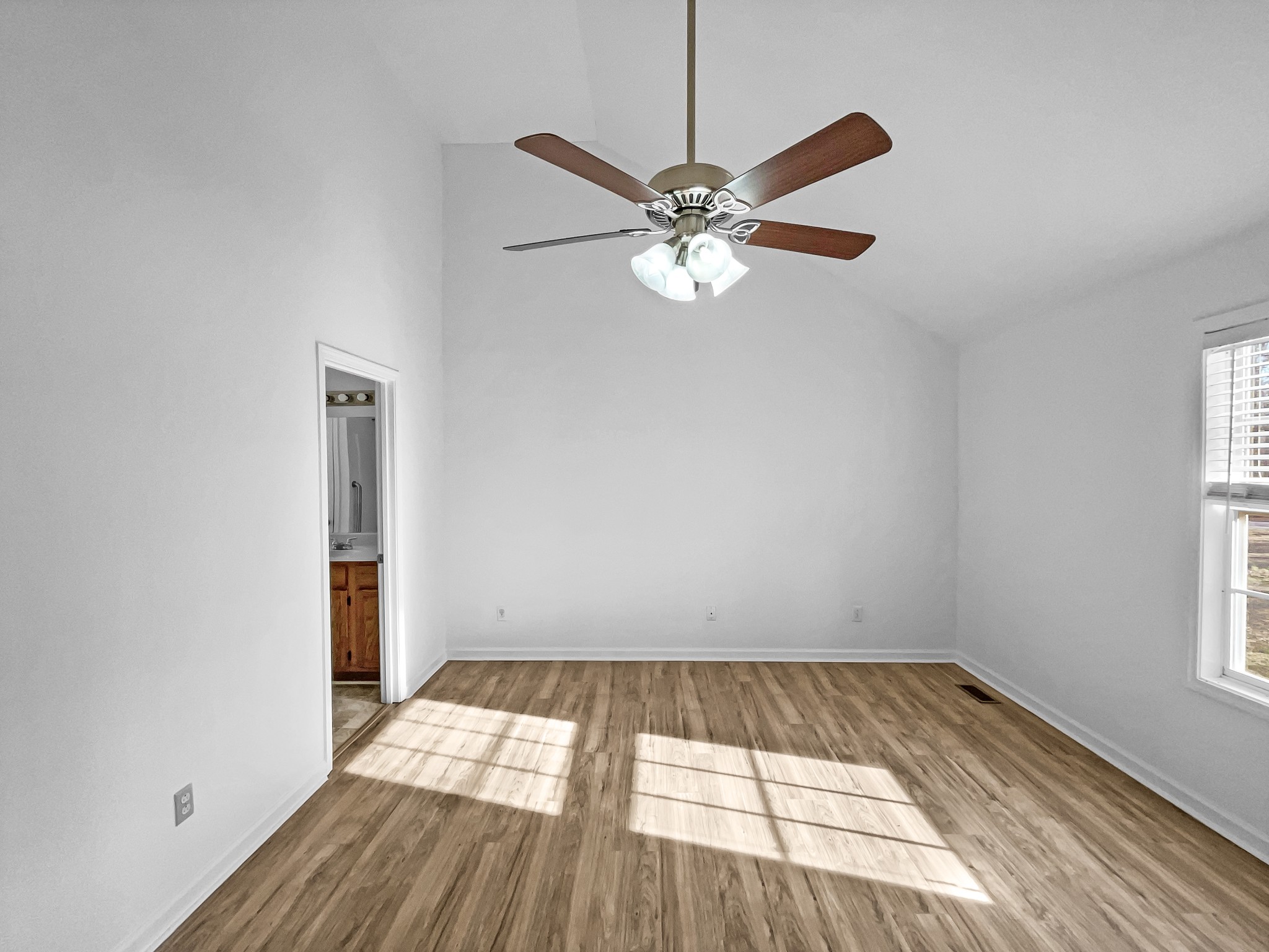2284 Wiley Pardue Road Ashland City, TN 37015 - Photo 10 of 19 an empty room with wooden floor fan and windows