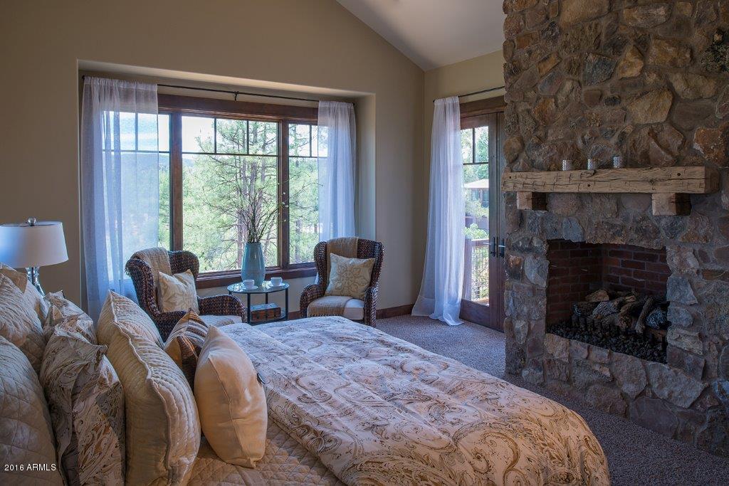 3003 East Arrow Point Payson, AZ 85541 - Photo 8 of 36 a spacious bedroom with a balcony a bed and a fireplace